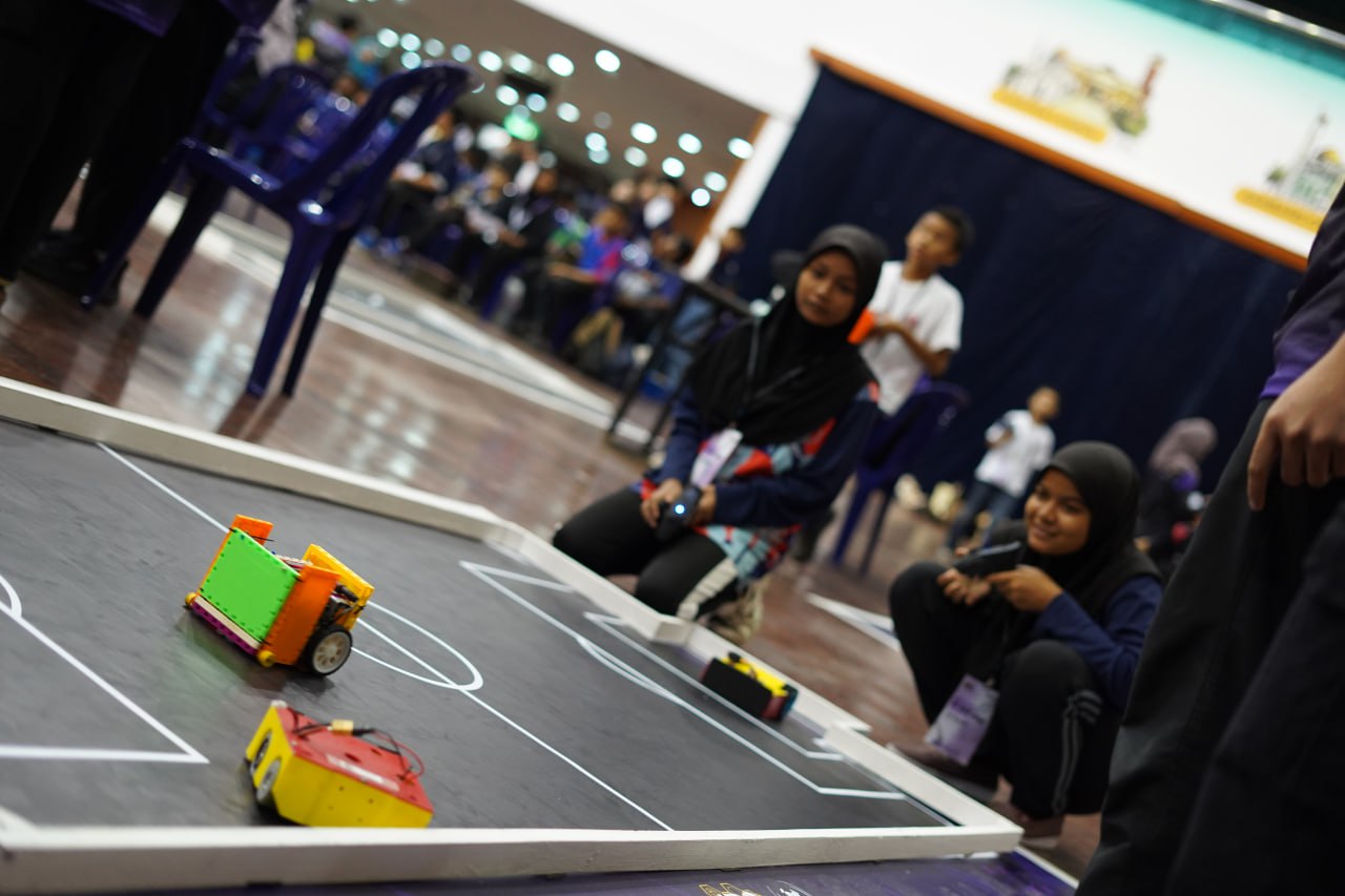 Robotics teams competing on the arena floor at IIUMRC 2025